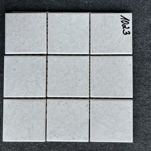Foto einer einzelnen quadratischen Mosaik-Fliese in beiger Farbe, leicht marmoriert.