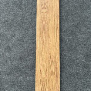 Foto einer einzelnen Bodenfliese in rot-brauner Farbe, Holzoptik, rektifiziert, im Format 20 cm mal 90 cm.
