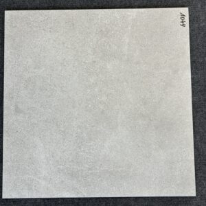 Foto einer einzelnen quadratischen Bodenfliese in grauer Farbe mit Struktur, die ihr einen gebrauchten, rissigen Look verleiht. rektifiziert.