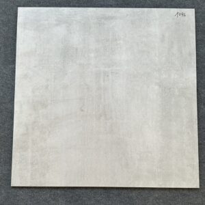 Foto einer einzelnen quadratischen Bodenfliese in hellem Grau mit Struktur, die ihr einen gebrauchten, rissigen Look verleiht. rektifiziert.