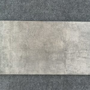 Foto einer einzelnen Bodenfliese in dunklem Grau mit Struktur, die ihr einen gebrauchten, rissigen Look verleiht. im Format 30cm x 60cm.