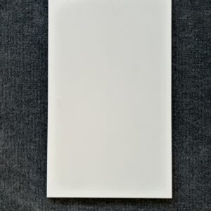 Foto einer einzelnen Wandfliese in mattem Weiß mit Naturkante.