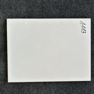 Foto einer einzelnen Wandfliese in weißer Farbe mit leichter Struktur und Naturkante.