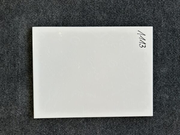 Foto einer einzelnen Wandfliese in weißer Farbe mit leichter Struktur und Naturkante.