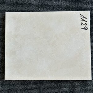 Foto einer einzelnen Wandfliese in beiger Farbe, leicht marmoriert, mit Naturkante.