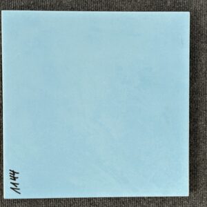 Foto einer einzelnen quadratischen Bodenfliese in hellblauer Farbe, leicht marmoriert und glasiert, mit Naturkante.