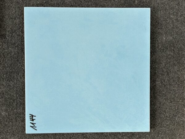 Foto einer einzelnen quadratischen Bodenfliese in hellblauer Farbe, leicht marmoriert und glasiert, mit Naturkante.