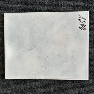 Foto einer einzelnen Fliese in grau-bläulicher Farbe, Format: 20cm x 25cm.