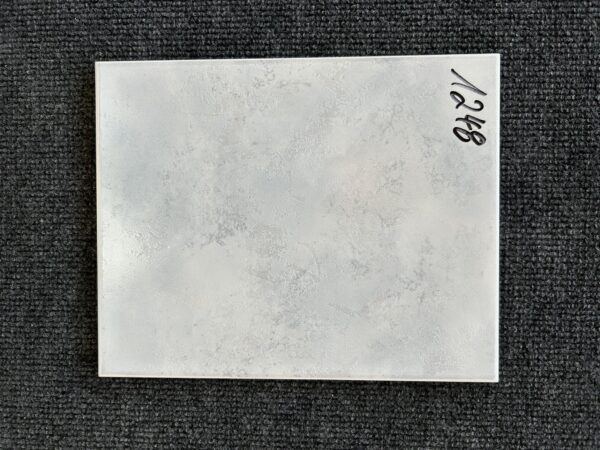 Foto einer einzelnen Fliese in grau-bläulicher Farbe, Format: 20cm x 25cm.