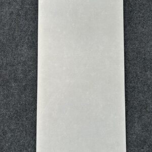 Foto einer einzelnen Wandfliese in hellgrauer Farbe, die das Format 30cm x 50cm hat.