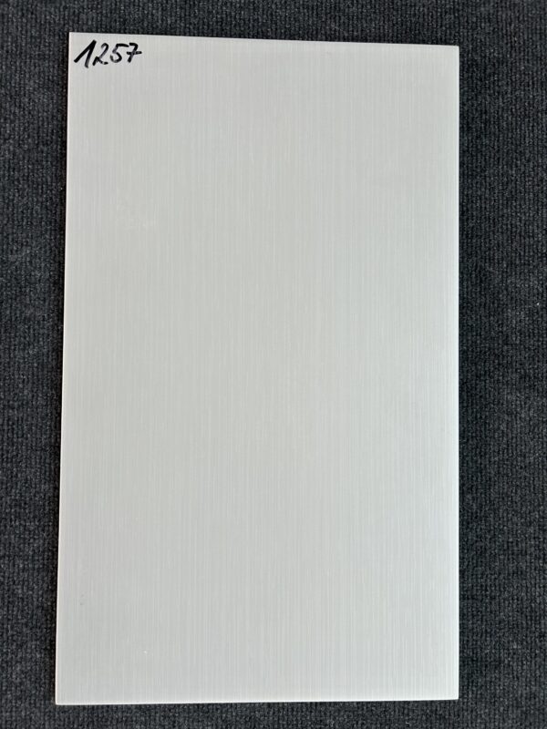 Foto einer einzelnen Wandfliese in beiger Farbe mit Holzoptik, die das Format 30cm x 50cm hat.
