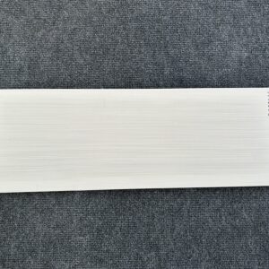 Foto einer einzelnen Wandfliese in grauer Farbe mit Holzoptik, die das Format 20cm x 60cm hat.