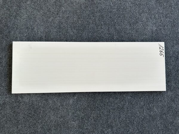 Foto einer einzelnen Wandfliese in beiger Farbe mit Holzoptik, die das Format 20cm x 60cm hat.