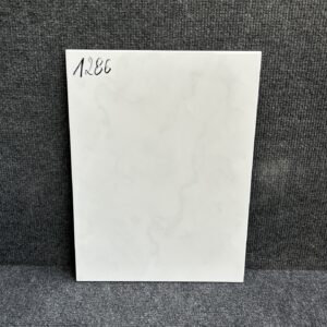 Foto einer einzelnen Wandfliese, weiß grau marmoriert. Im Format 25cm x 33cm.