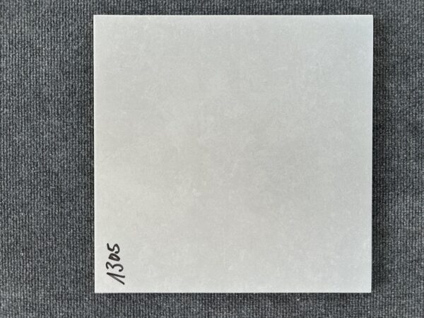 Foto einer einzelnen, quadratischen Bodenfliese in grauem Farbton.