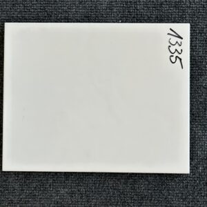 Foto einer einzelnen Wandfliese weiß matt gewellt, im Format 20cm x 25cm.