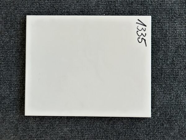 Foto einer einzelnen Wandfliese weiß matt gewellt, im Format 20cm x 25cm.