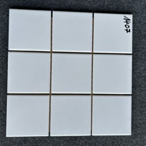 Foto einer einzelnen Mosaik-Fliese, alle Felder des Mosaiks sind in einem glänzenden Weiß gehalten.