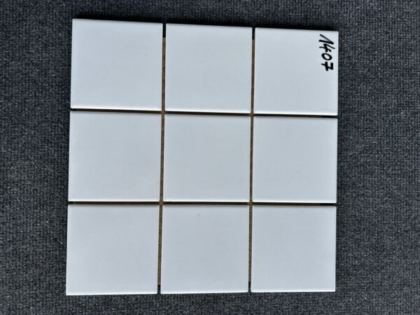 Foto einer einzelnen Mosaik-Fliese, alle Felder des Mosaiks sind in einem glänzenden Weiß gehalten.