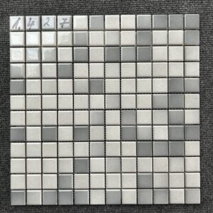 Foto einer einzelnen, quadratischen Mosaik-Fliese. Die Felder der Mosaik-Fliese sind in verschiedenen, glänzenden Grautönen gehalten.