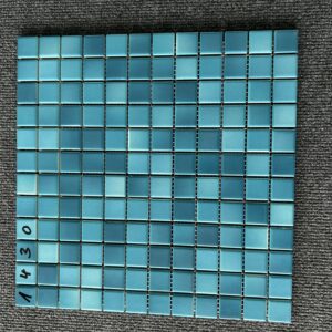 Foto einer einzelnen, quadratischen Mosaik-Fliese. Die Felder der Mosaik-Fliese sind in blauen und grünen Farbtönen gehalten.