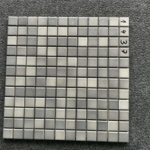 Foto einer einzelnen, quadratischen Mosaik-Fliese. Die Felder der Mosaik-Fliese sind in verschiedenen, matten Grautönen gehalten.