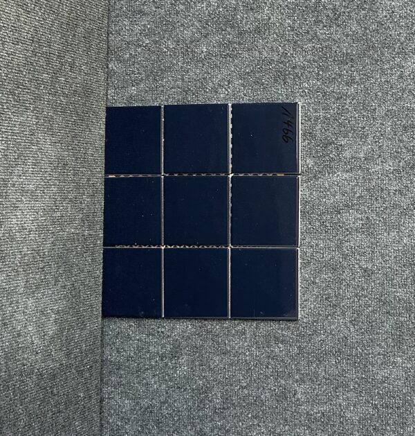Foto einer einzelnen, quadratischen Mosaik-Fliese. Die Felder der Mosaik-Fliese sind in einem dunkelblauen Farbton gehalten.