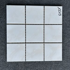 Foto einer einzelnen, quadratischen Mosaik-Fliese. Die Felder der Mosaik-Fliese sind in einem cremigen Weiß gehalten.