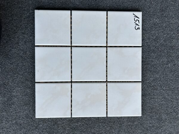 Foto einer einzelnen, quadratischen Mosaik-Fliese. Die Felder der Mosaik-Fliese sind in einem cremigen Weiß gehalten.