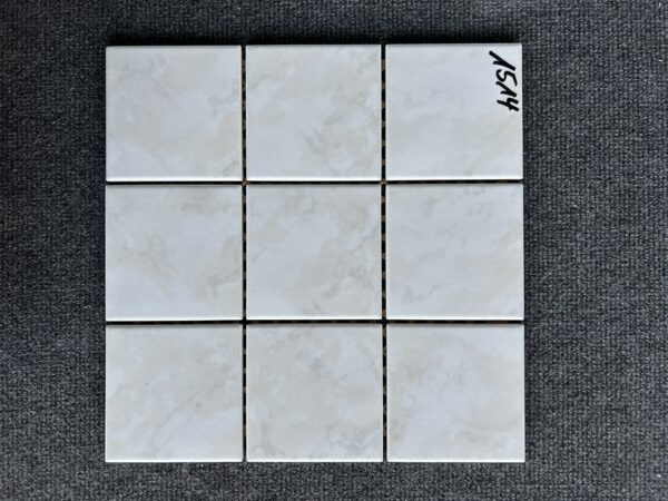 Foto einer einzelnen, quadratischen Mosaik-Fliese. Die Felder der Mosaik-Fliese sind in grau-beige gehalten.