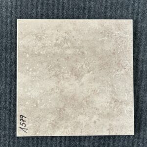 Foto einer einzelnen Bodenfliese Feinsteinzeug im Format 33 cm x 33 cm und einem rauchigen Beige-Farbton.