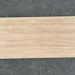 Foto einer einzelnen Bodenfliese Feinsteinzeug im Format 30 cm x 60 cm. Sie ist im Farbton Cappuccino gehalten, einem warmen, milchigen Braun. Die Fliese hat eine Buche nachempfundene Holzoptik.