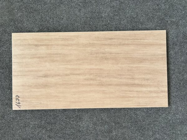 Foto einer einzelnen Bodenfliese Feinsteinzeug im Format 30 cm x 60 cm. Sie ist im Farbton Cappuccino gehalten, einem warmen, milchigen Braun. Die Fliese hat eine Buche nachempfundene Holzoptik.