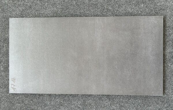 Foto einer einzelnen Bodenfliese Feinsteinzeug im Format 30 cm mal 90 cm. Sie ist im Farbton Graphit gehalten, der an ein dunkles Grau, das noch nicht ganz schwarz ist, erinnert.