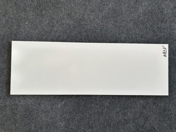 Foto einer einzelnen Wandfliese in glänzendem Weiß. Das Format beträgt 25 cm mal 75 cm.