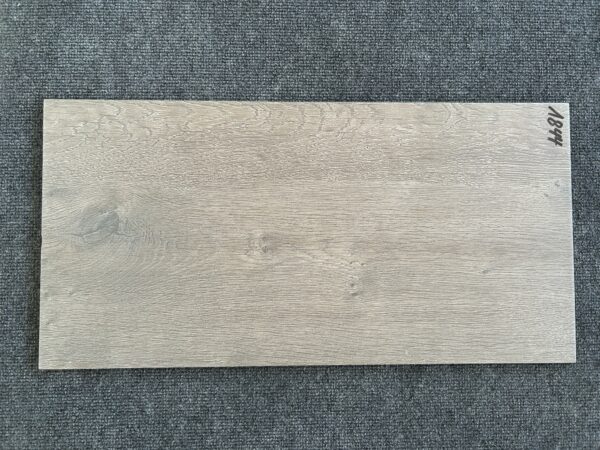 Foto einer einzelnen Bodenfliese Feinsteinzeug im Format 30 cm mal 60 cm. Die Fliese ist in einem hellen Braun gehalten und optisch Holz nachempfunden.