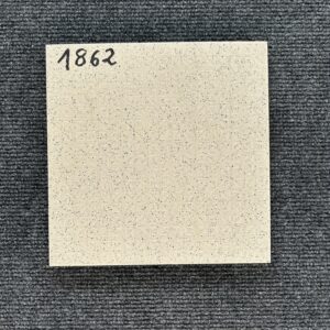 Foto einer einzelnen, quadratischen Bodenfliese Feinsteinzeug im Format 20 cm x 20 cm. Die Fliese ist im Farbton Beige gehalten und besitzt ein Muster aus Punkten und Quadraten, das ihr eine auffällige Optik verleiht.