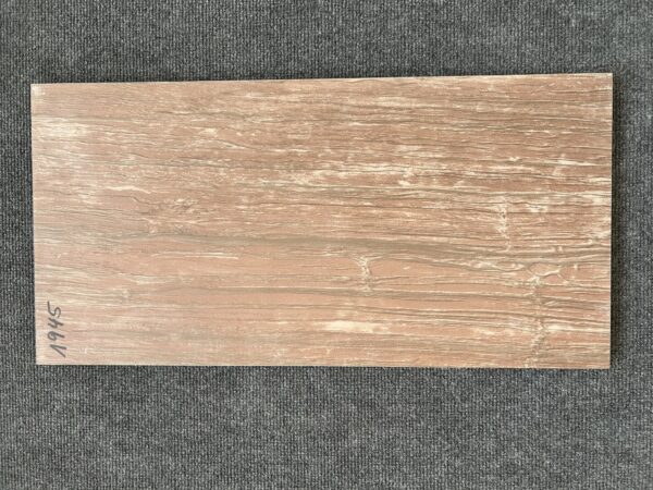 Foto einer einzelnen Bodenfliese Feinsteinzeug im Format 30 cm x 60 cm. Diese Fliese hat einen rötlichen Braunton und ist in Holzoptik gehalten, die kaum von echtem Holz zu unterscheiden ist.