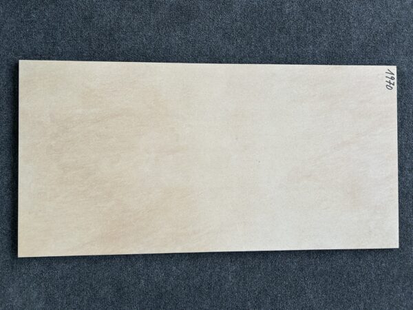 Foto einer einzelnen Bodenfliese Feinsteinzeug im Format 45 cm x 90 cm. Farblich ist die Fliese beige anpoliert, das heißt, dass sie teilweise glänzendes und teilweise mattes Beige aufweist.