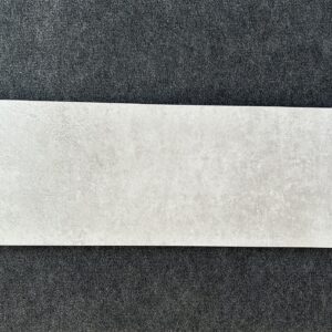 Foto einer einzelnen Wandfliese im Farbton grau-beige. Format: 30 cm x 90 cm.