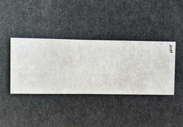 Foto einer einzelnen Wandfliese im Farbton grau-beige. Format: 30 cm x 90 cm.