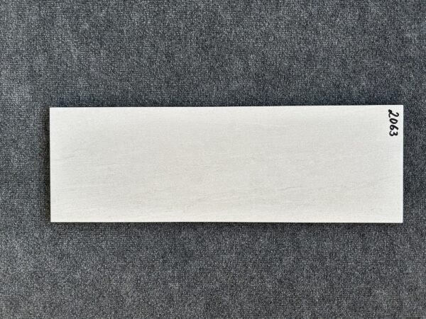 Foto einer einzelnen Wandfliese in mattem Weißgrau. Format: 20cm x 60cm.