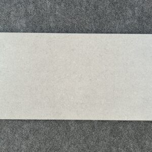 Foto einer einzelnen Bodenfliese Feinsteinzeug im Format 30cm mal 60cm und steingrauem Farbton.