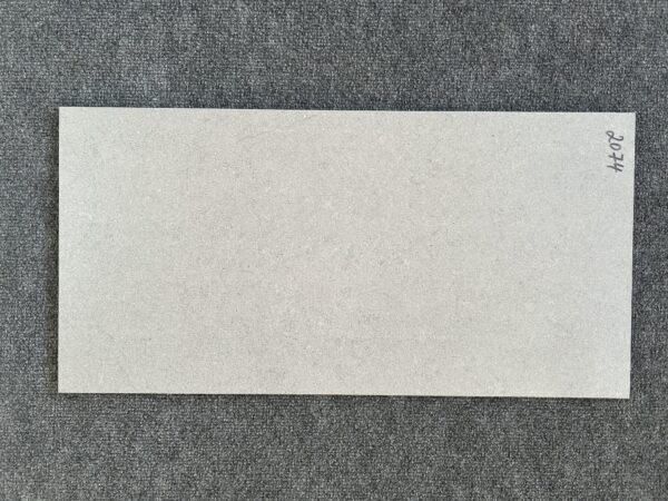 Foto einer einzelnen Bodenfliese Feinsteinzeug im Format 30cm mal 60cm und steingrauem Farbton.